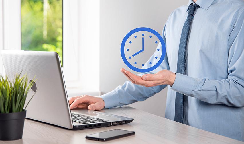 An immigration attorney sitting at his desk in front of a computer, with a clock icon hovering over his hand.