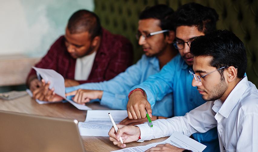 A group of Indian investors filling out forms to transfer from H-1B to EB-5 visa.