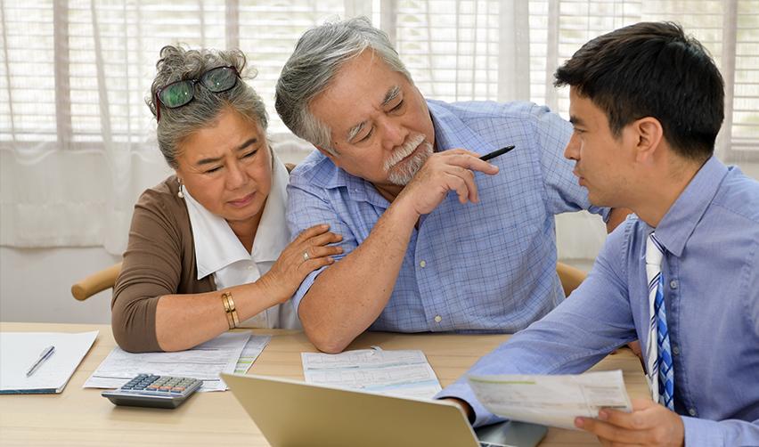 A primary applicant and investor's spouse working on some documents at a desk with an EB5 expert.