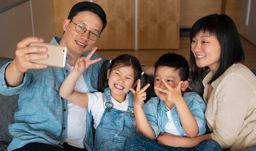Immigrant investors and their family members smiling at the camera.