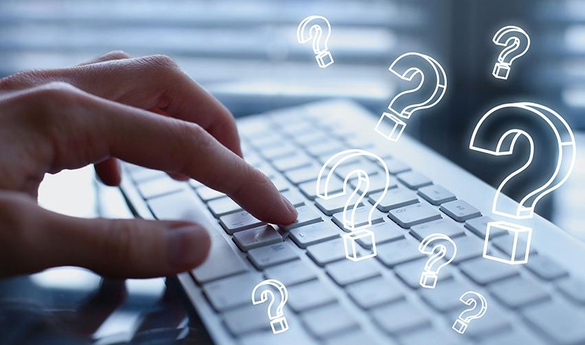 Digital question mark icons above a keyboard, referring to EB5 visa frequently asked questions or FAQs.