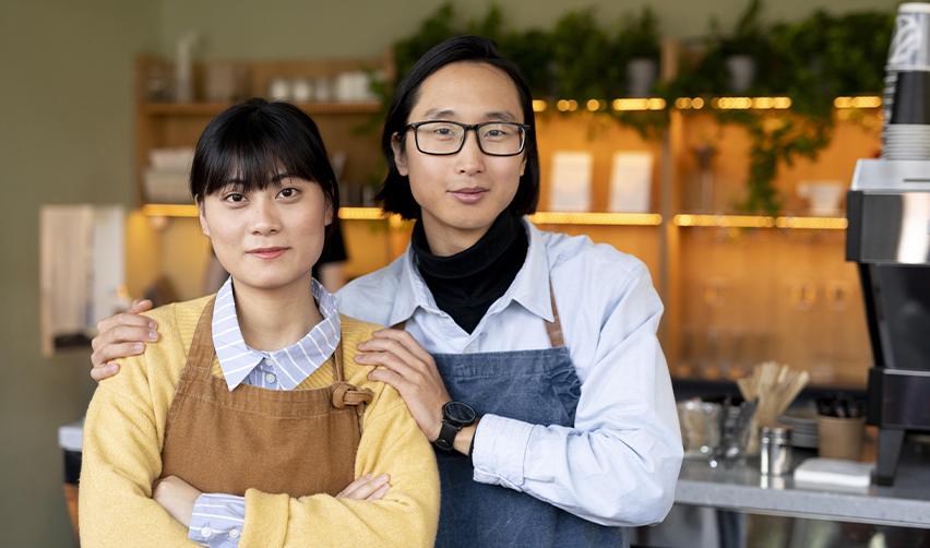 Two eb5 permanent residents looking at the camera in their small business.