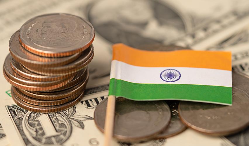 A small Indian flag on top of some investment capital money, symbolizing eb5 for Indian investors.