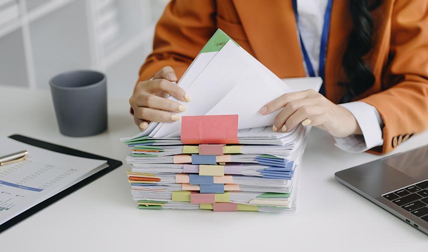 A United States Citizenship and Immigration Services official going over a stack of visa application documents, symbolizing priority processing for rural eb5 projects.