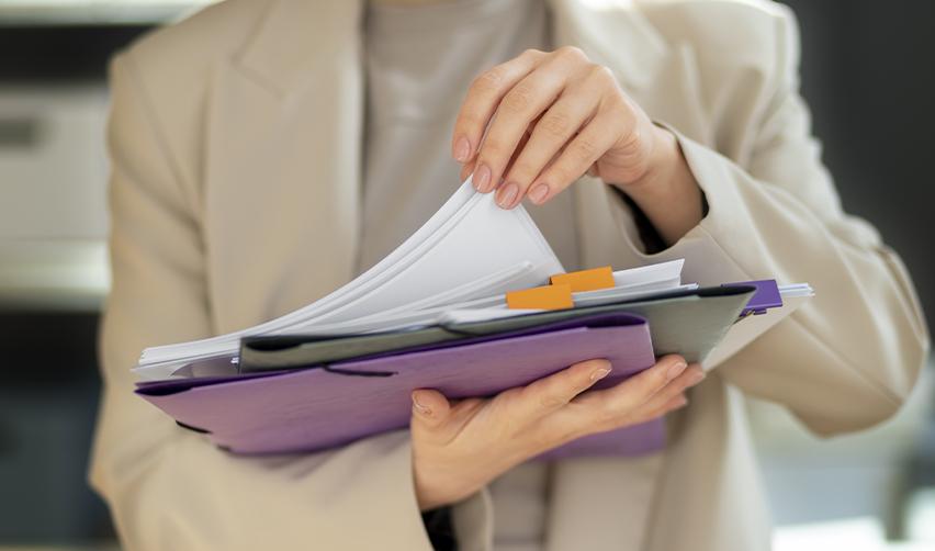 An EB5 immigration attorney holding some files and folders for supporting documents.