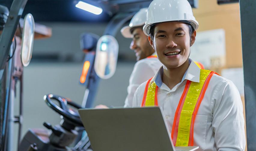 A Singaporean worker and US visa holder working on his computer in a hard hat.
