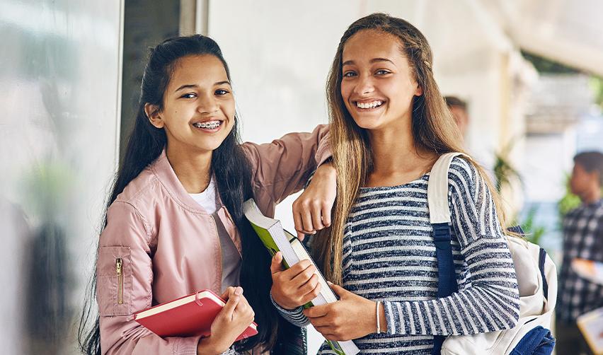Two international students smiling at the camera, after finding out what to do if F1 visa gets rejected.