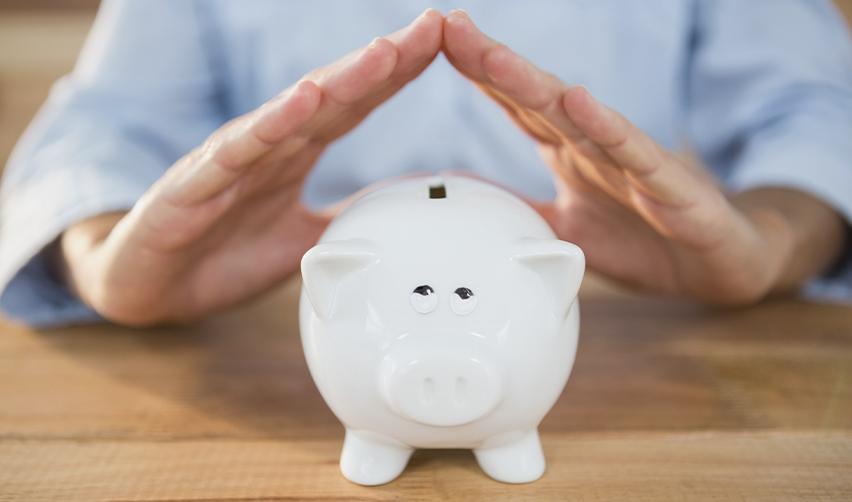 Hands protecting a piggy bank, symbolizing financial protections offered by reputable EB5 regional centers for secure investments.