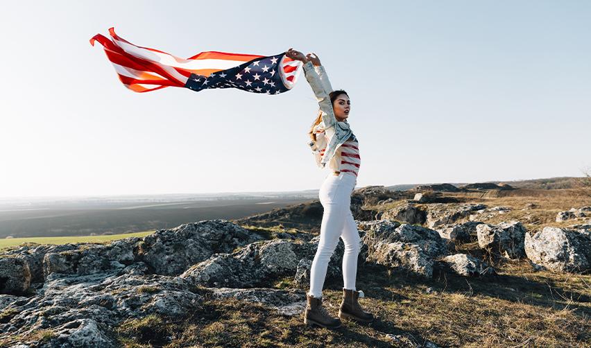 A targeted employment area investor holding up the American flag.