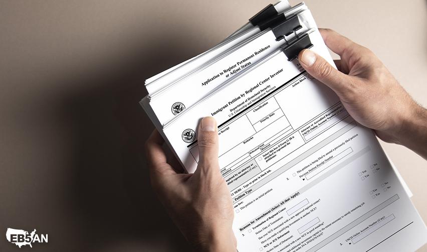 USCIS EB5 visa application forms held by an investor preparing for the EB5 process. Learn about EB5 immigration and investment requirements from EB5AN.
