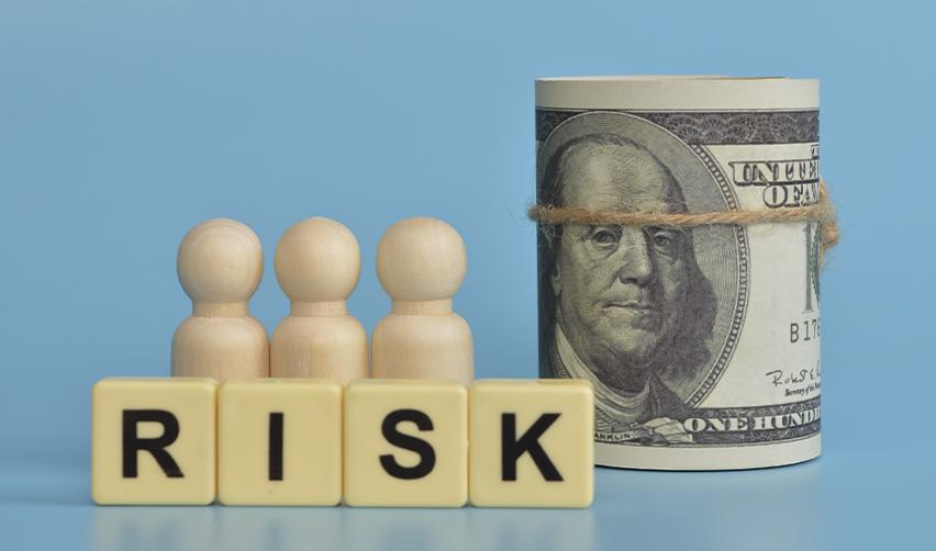 Wooden investor figures and U.S. hundred-dollar bills illustrating EB5 capital at risk in investment-based immigration projects.