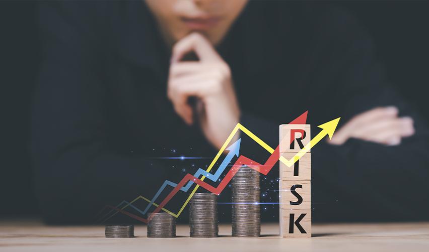 EB5 investor analyzing risk with growing coin stacks and fluctuating chart representing financial risk in U.S. projects.