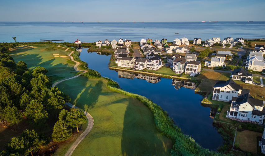 A golf course with houses and a body of water