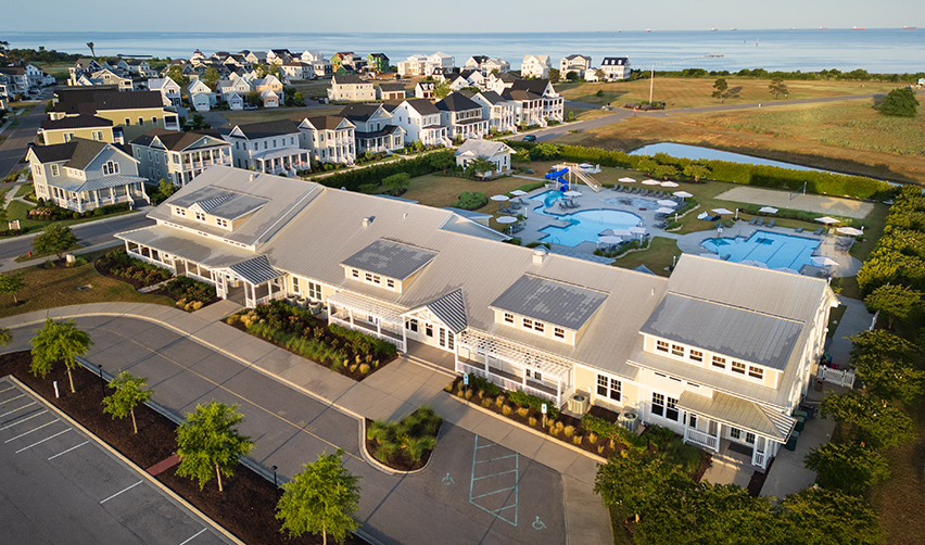 A large building with a pool and a body of water