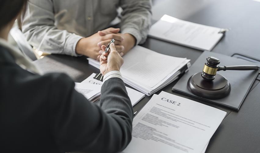 A lawyer reviewing case documents with a client during an EB5 consultation, symbolizing legal support in immigration matters.
