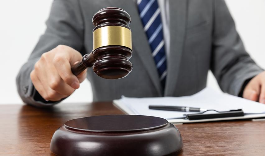 A close-up of a judge’s gavel about to strike, symbolizing USCIS adjudication trends and EB5 petition approvals.