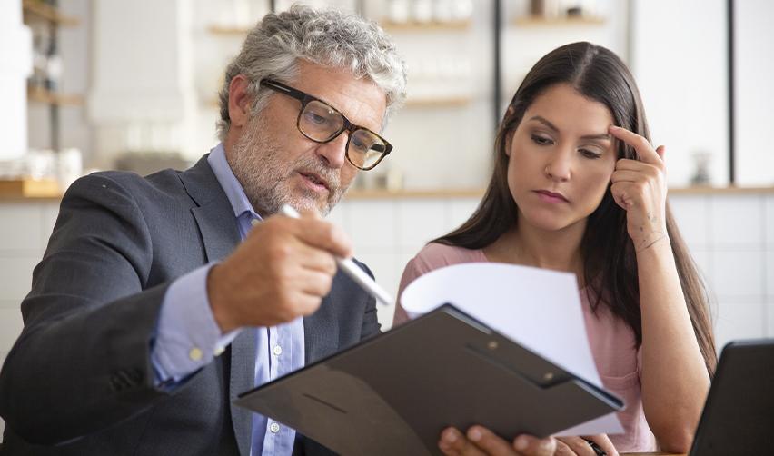 A seasoned immigration attorney going over EB5 paperwork with a concerned client, highlighting the importance of experienced legal guidance.
