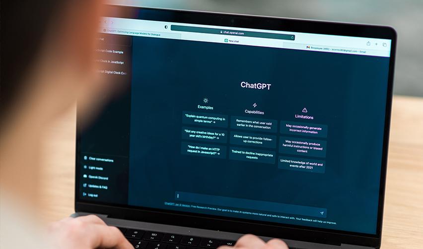 A person using ChatGPT on a laptop, with the interface showing examples, capabilities, and limitations—illustrating how AI tools like GPT-5 are applied in EB5 investment analysis.