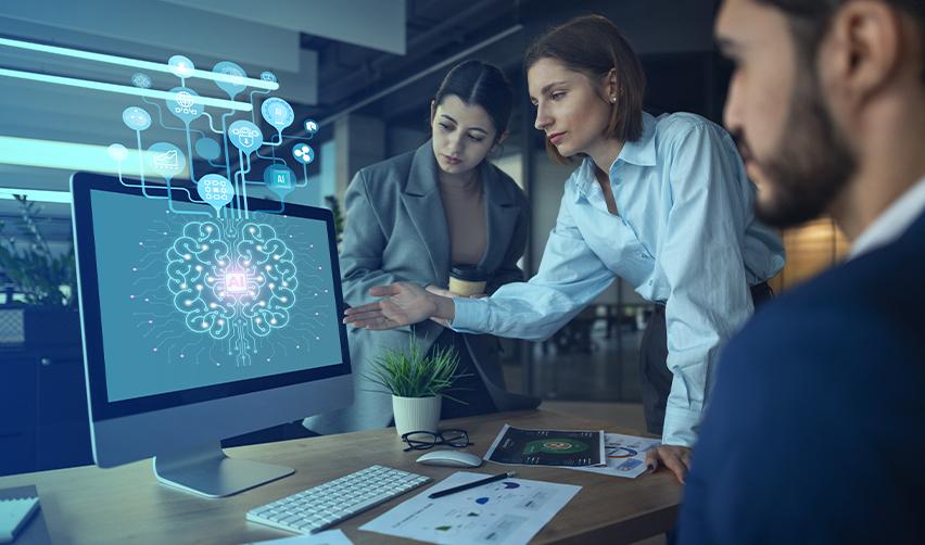 Team of professionals analyzing AI brain visualization on a computer screen in a modern office, symbolizing AI tools supporting EB5 investors in due diligence and decision-making.