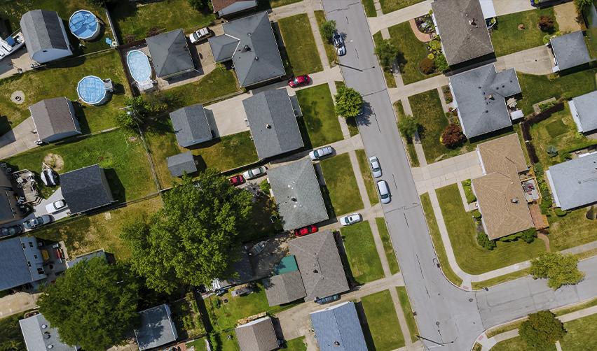 Aerial view of suburban houses, streets, and backyards, representing real estate development opportunities in EB5 projects and community growth.