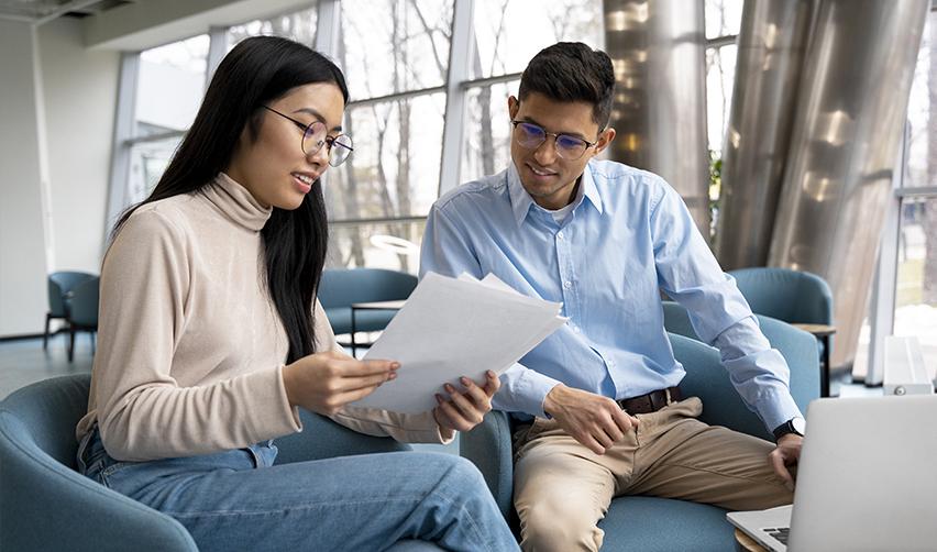 Two professionals sitting together and reviewing documents, symbolizing EB5 investors consulting experts and conducting due diligence with guidance from trusted advisors.