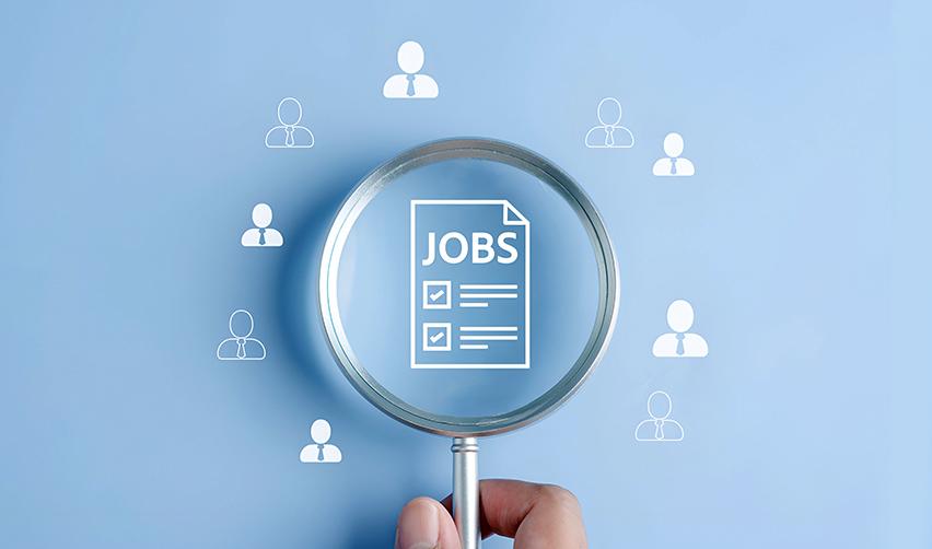 Magnifying glass focusing on a jobs document, highlighting how EB5 projects must create U.S. jobs to support Green Card approval.