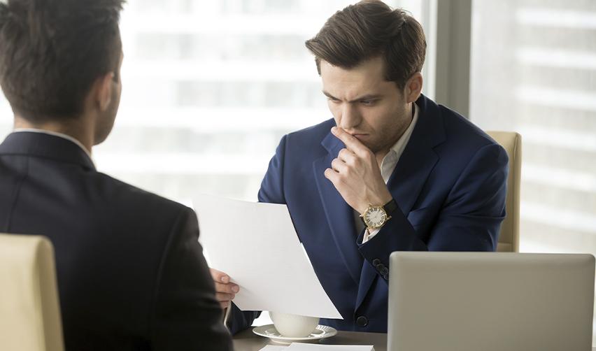 Businessman carefully reviewing documents in an office, symbolizing USCIS scrutiny of EB5 job creation evidence.
