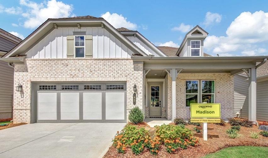 Front view of the Madison model at Cresswind at Spring Haven, featuring a brick exterior, wide front porch, and landscaped entry, showcasing one of Kolter Homes’ Silver OBIE Award winners within its EB5 active adult communities.