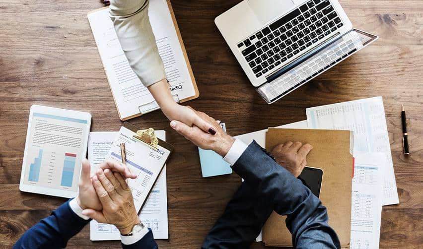 Investors and advisors reviewing documents at a table, symbolizing EB5 planning, adjustment of status filing, and investment-based immigration decisions.