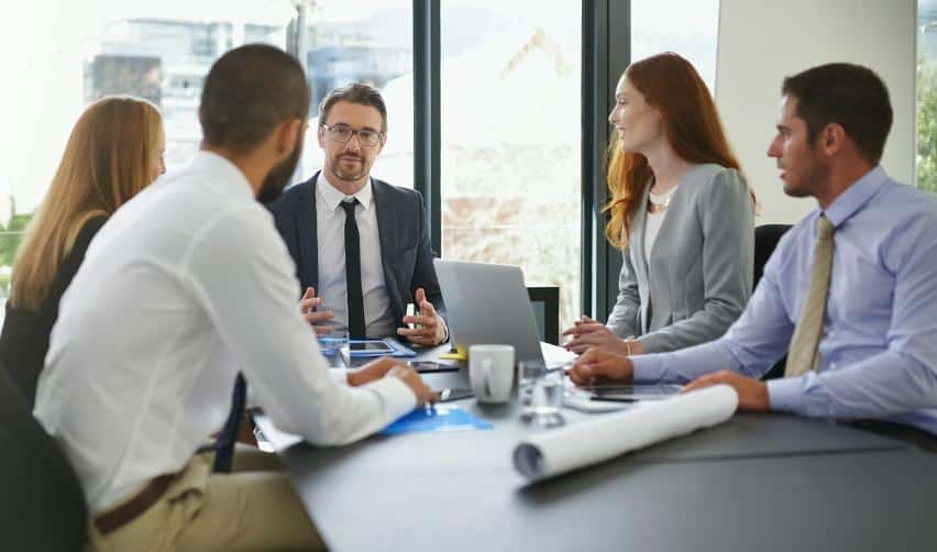 A team discussing EB5 project details in a conference setting, highlighting the value of direct answers on risk, structure, and strategy from EB5AN principals.
