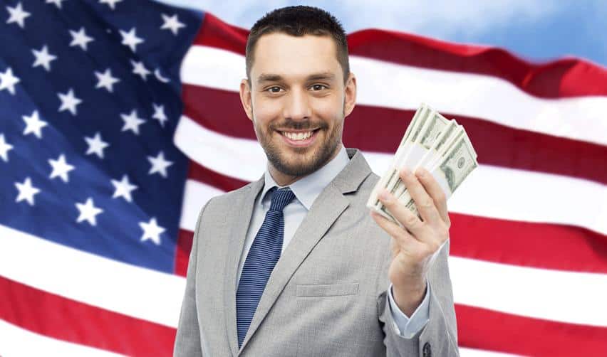 A professional EB5 investor holding U.S. dollar bills in front of an American flag, symbolizing capital investment as part of the EB5 Green Card process.